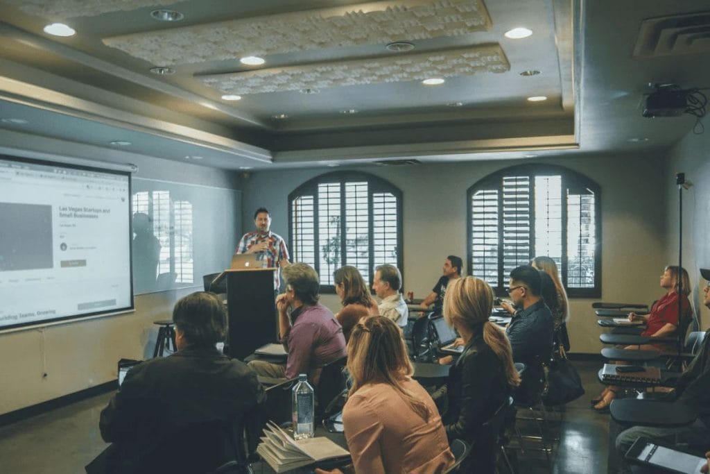 A man giving a presentation to a group in a classroom setting.