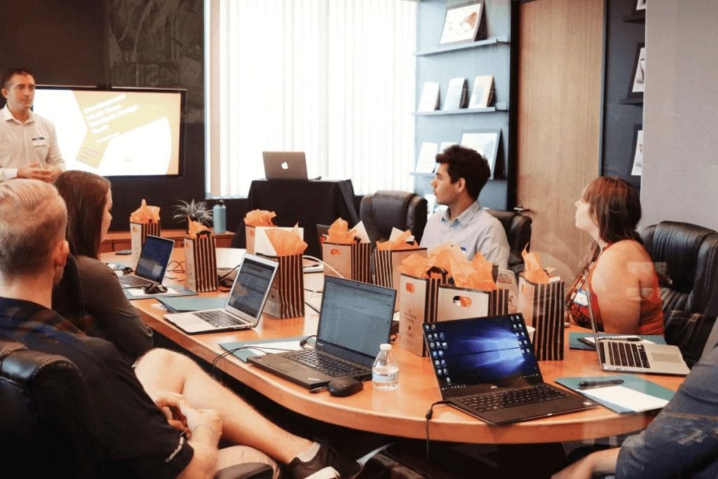 Team meeting with participants listening to a presenter in a conference room.