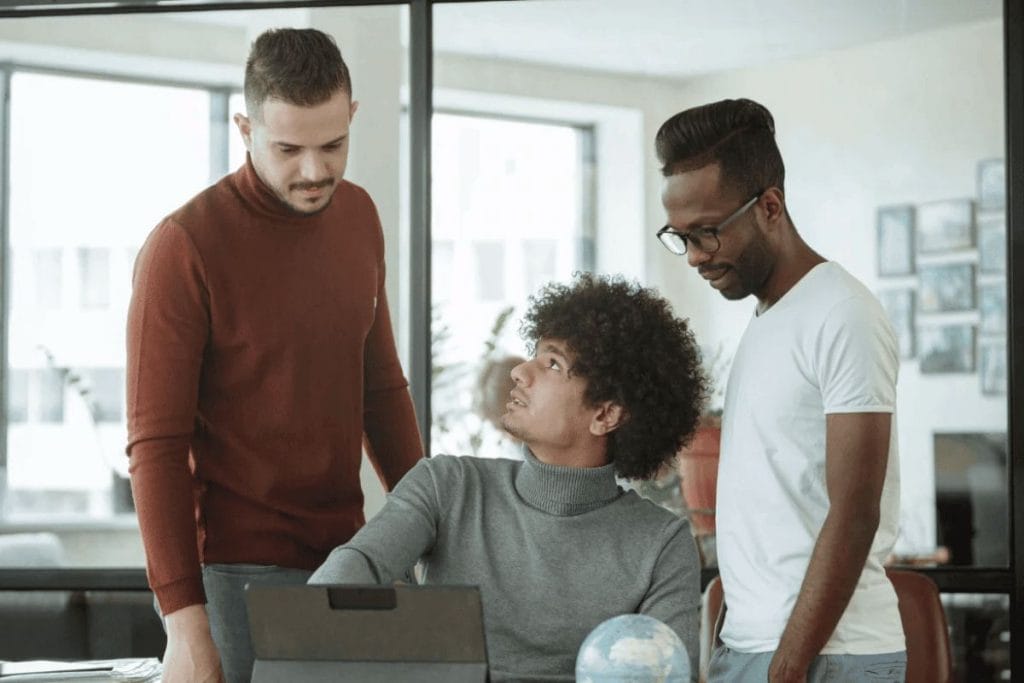 Team members engaged in a conversation in an office setting.
