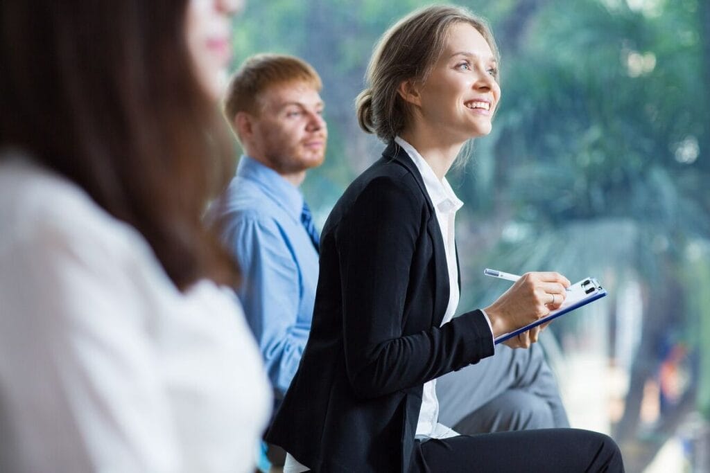 Woman taking notes at a business seminar.