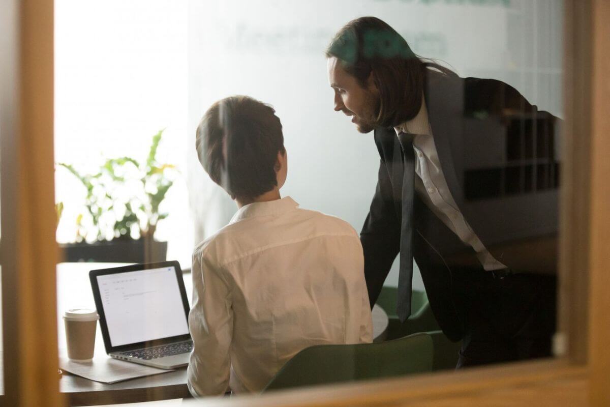 Two professionals in discussion inside a modern office.