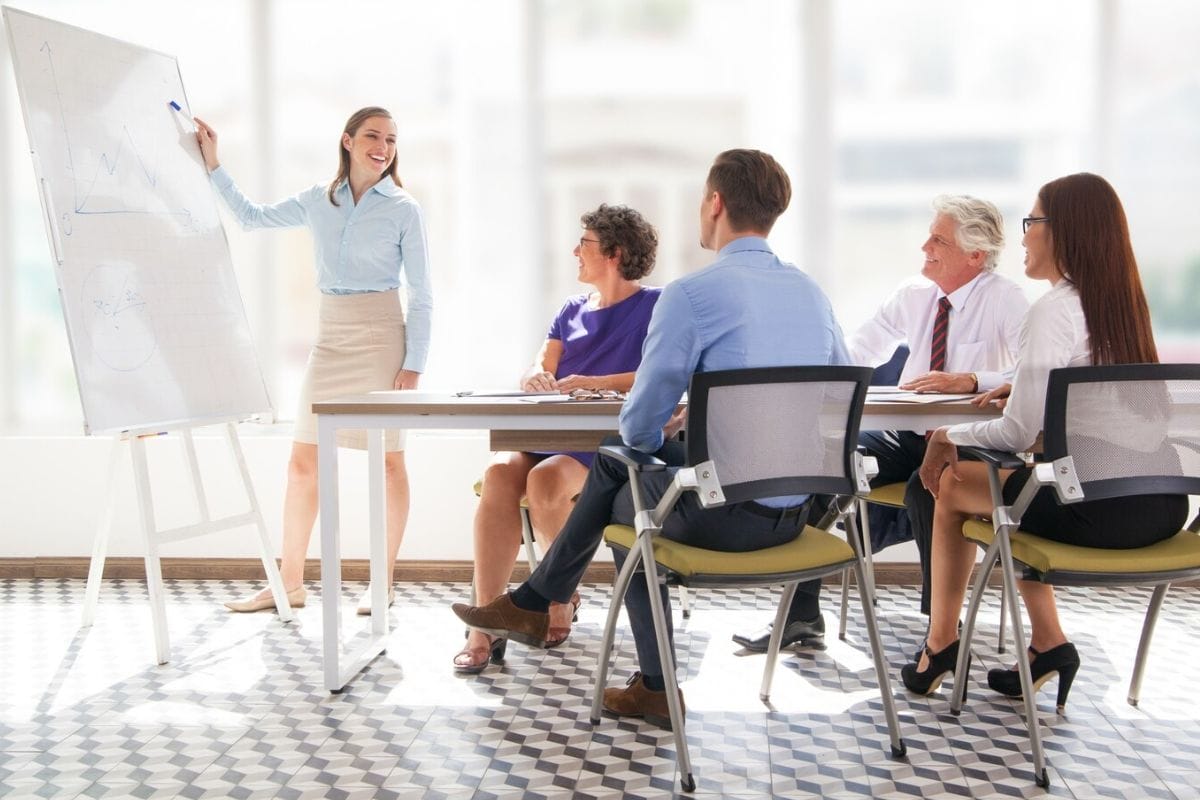 A woman presenting in front of her colleagues.