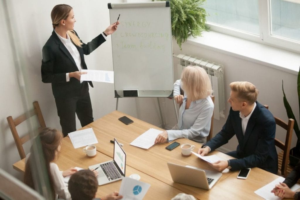 A professional presenting in front of her colleagues.