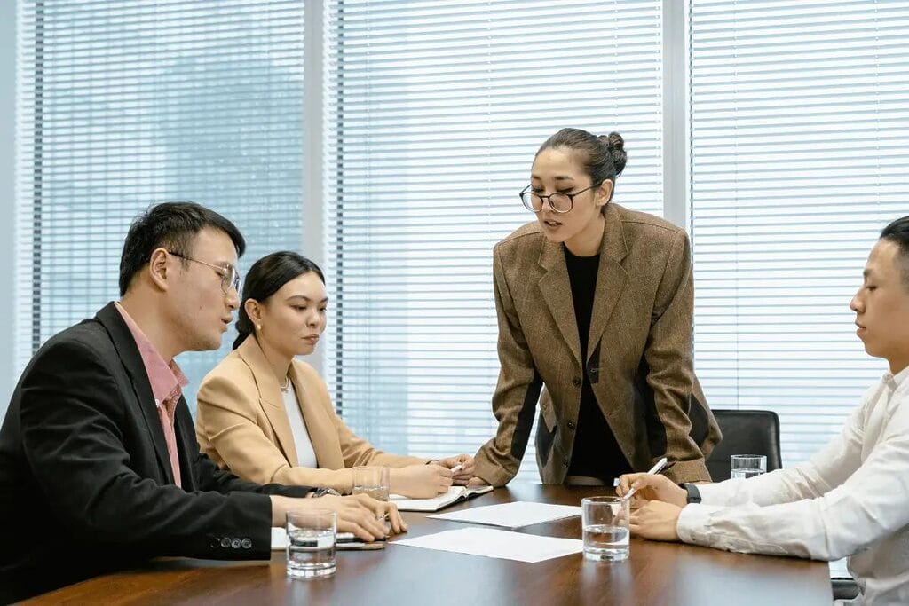 Businesswoman leading a meeting while colleagues listen.