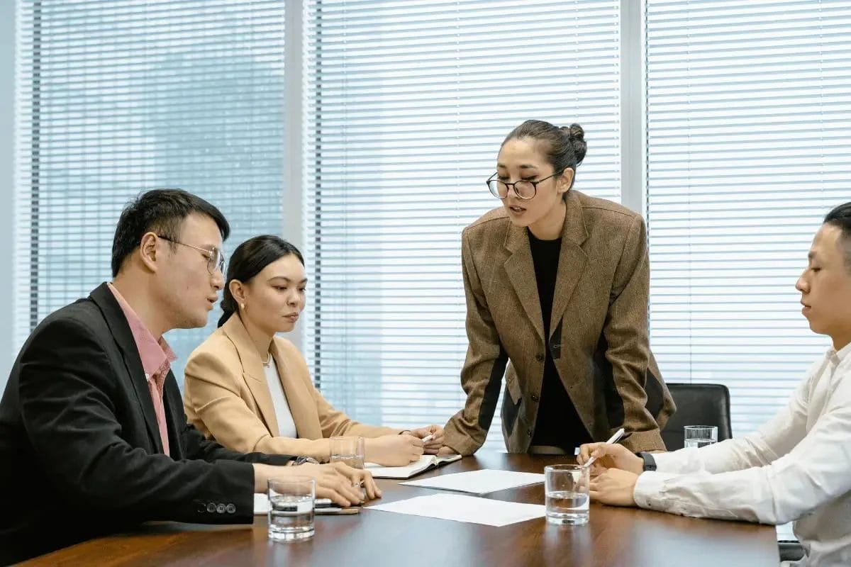 Business team in a meeting with a leader discussing documents.
