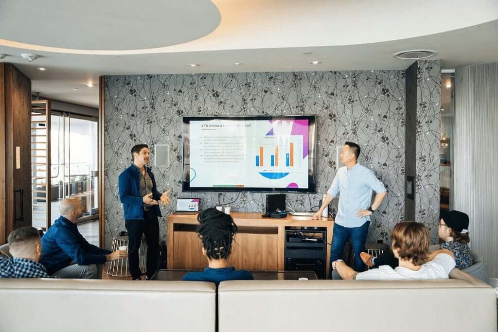 Corporate meeting with employees watching a detailed presentation on growth charts.