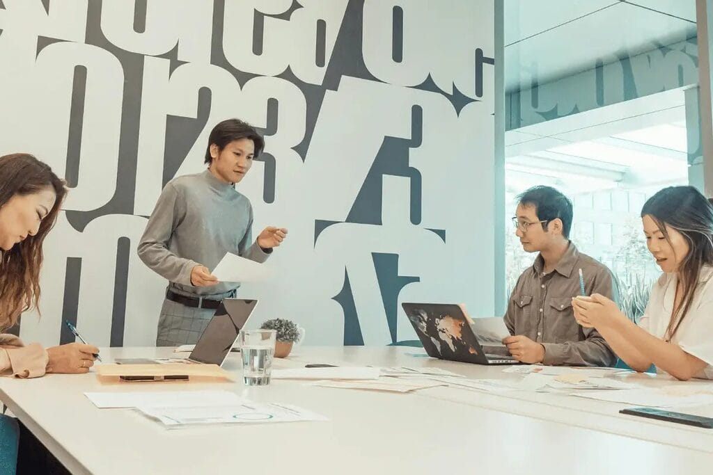 Business meeting with a presenter and colleagues discussing documents.