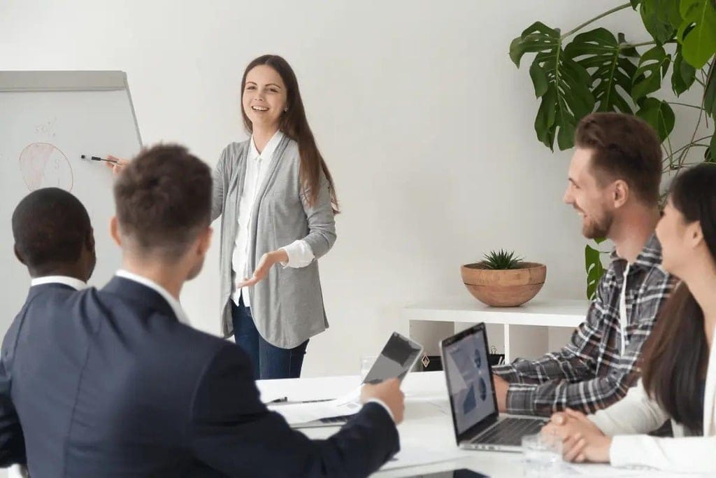 Businesswoman leading a presentation with colleagues listening attentively.