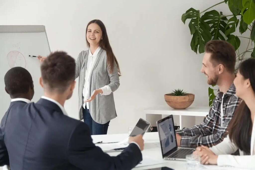 Businesswoman leading a presentation with colleagues listening attentively.