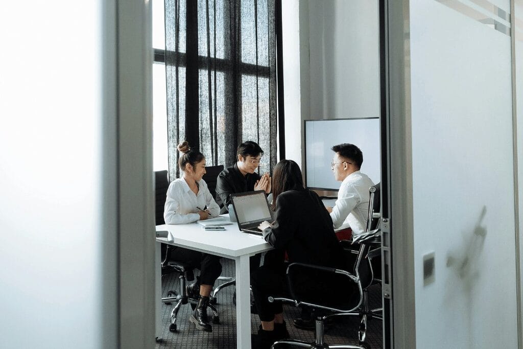 Colleagues in a casual meeting, focusing on a team member presenting ideas on a flip chart.