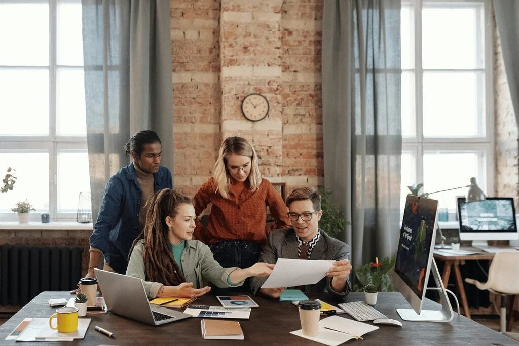 Creative team reviewing project details in a modern workspace.