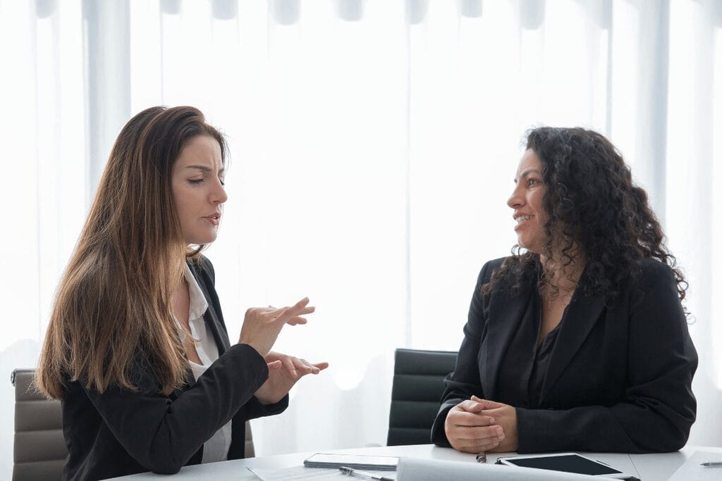 Two professionals in a discussion at a bright office setting.