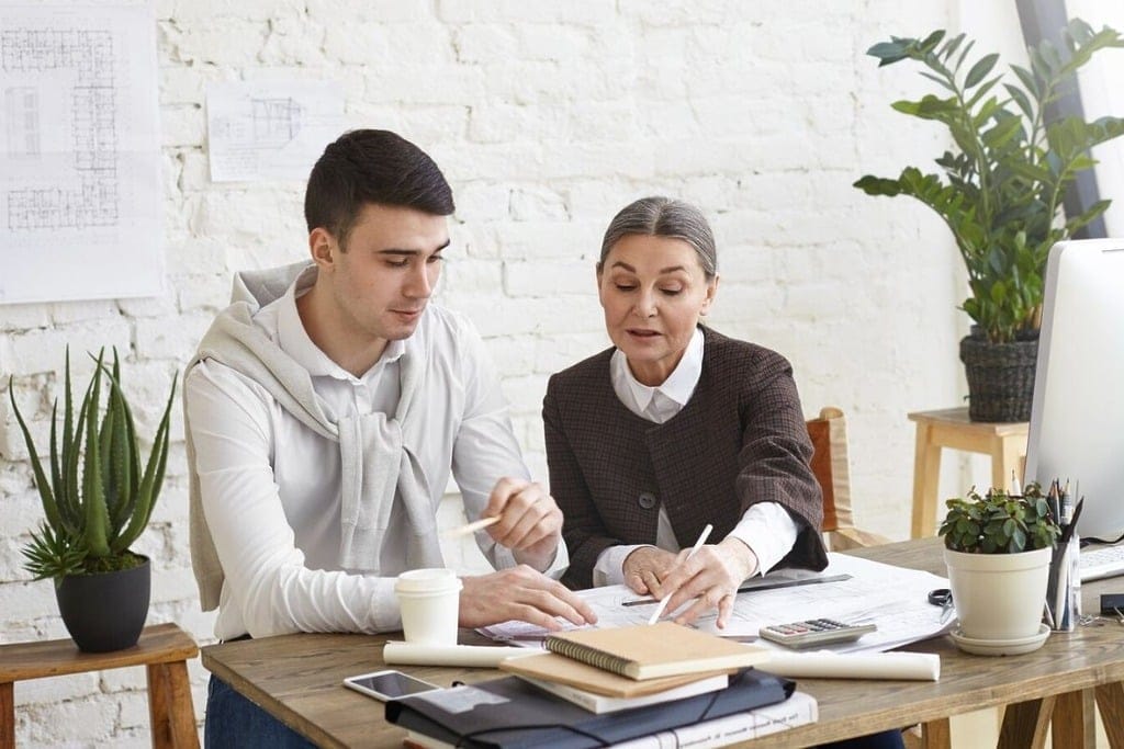 Two colleagues discussing a project at a desk.