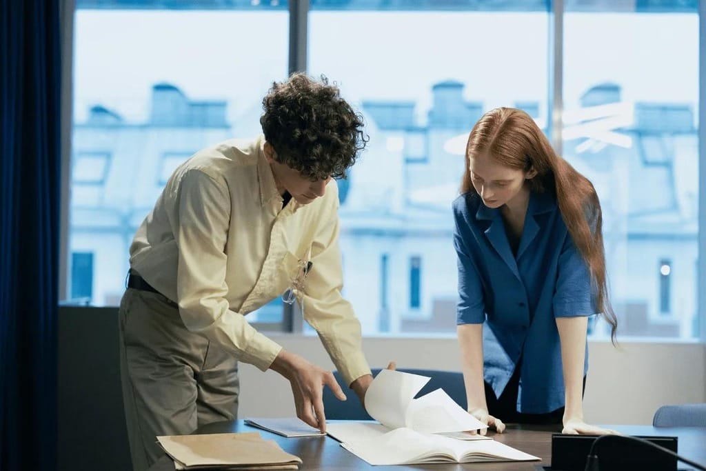 Two colleagues reviewing documents together at a desk.
