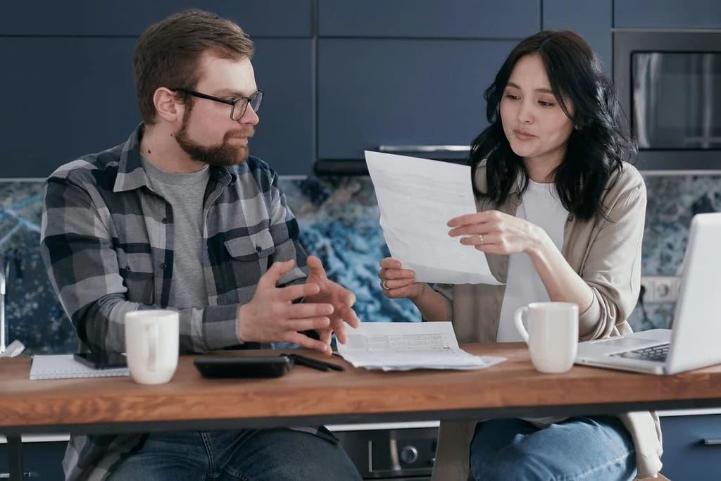 Young professionals discussing ideas while working at their desks.