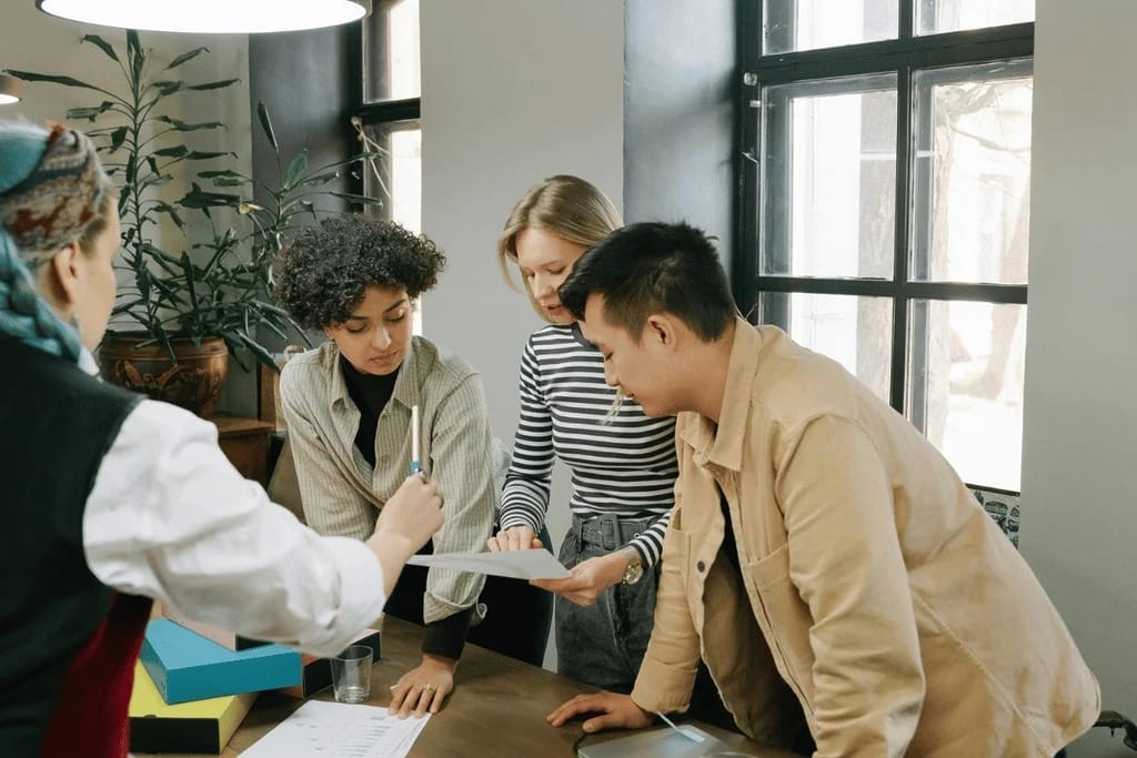 A focused team collaborating on a project while looking at a document.