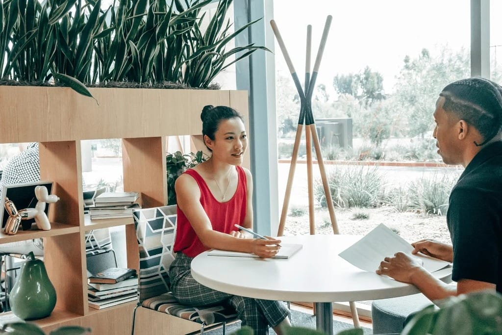Professional discussion with documents and notebooks in a meeting.