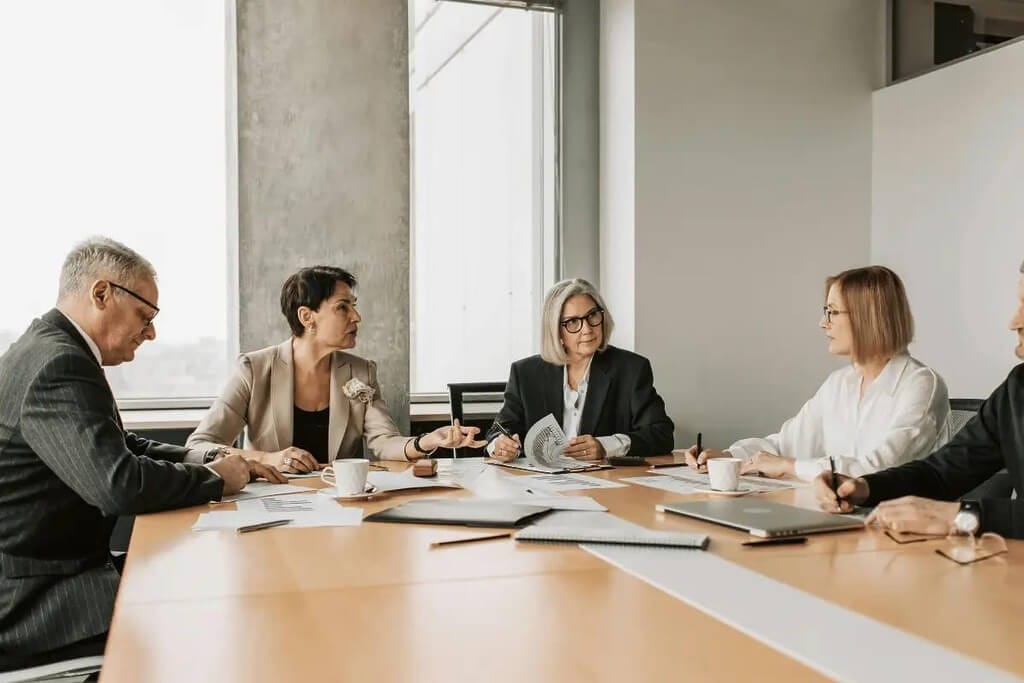 Business meeting with professionals discussing documents in a modern conference room.