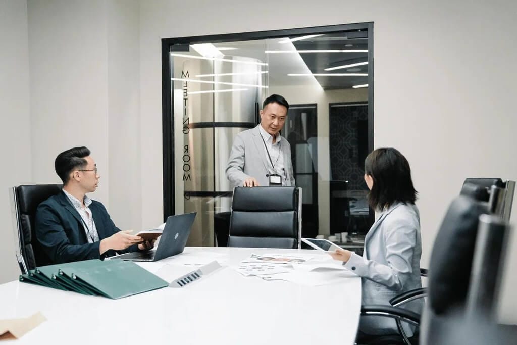 Business meeting with three professionals in a conference room.