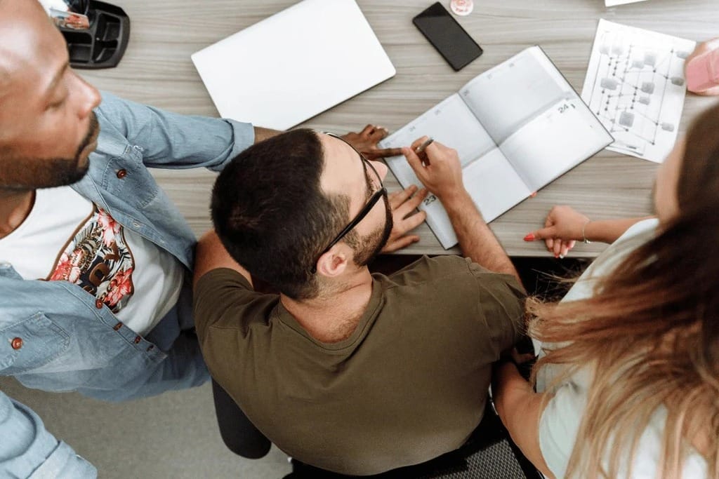 Businesswoman presenting in a meeting with colleagues around a table.