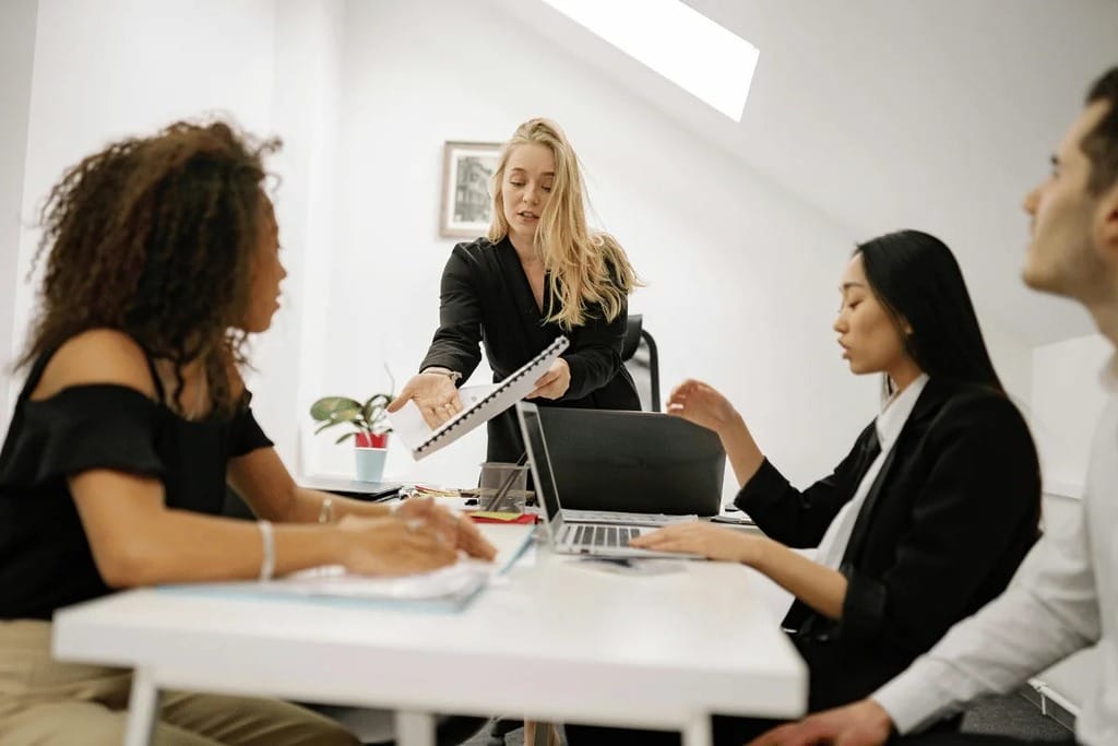 Colleagues engaged in a presentation led by a female team member.
