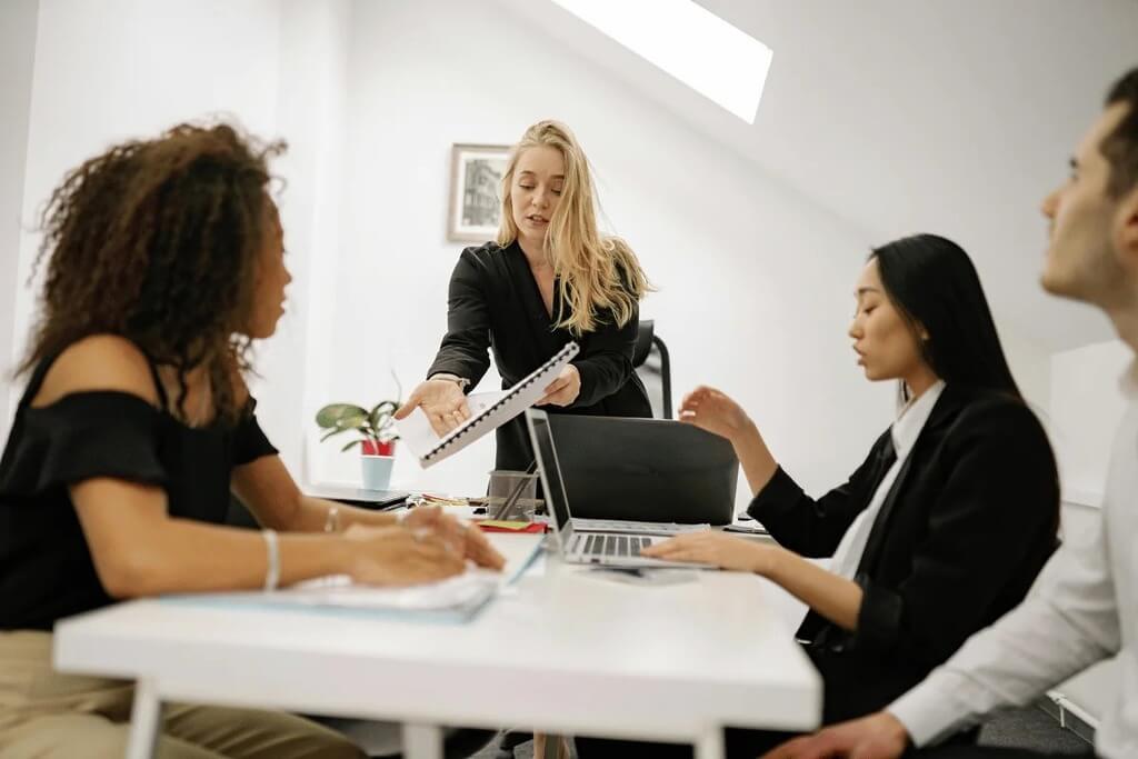 Colleagues engaged in a presentation led by a female team member.