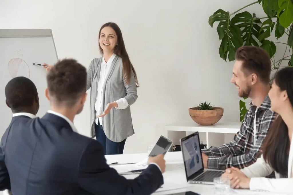 Business presentation with a woman leading the discussion, using a whiteboard.
