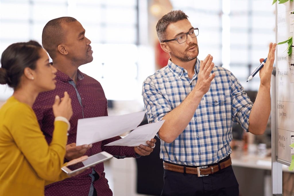 A team collaborating during a business presentation in a modern office.