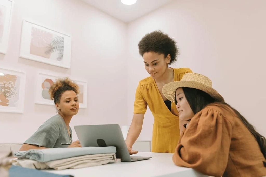 Three women collaborating on a project in a creative workspace.