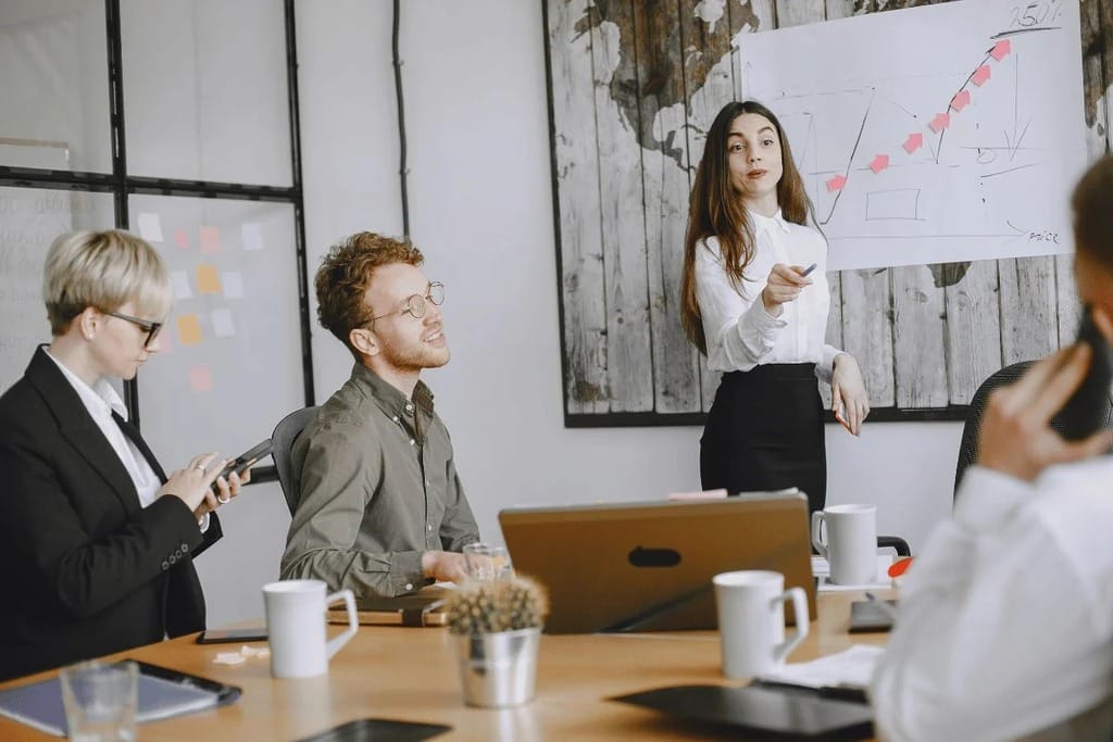 Team discussion with a man explaining ideas on a whiteboard.