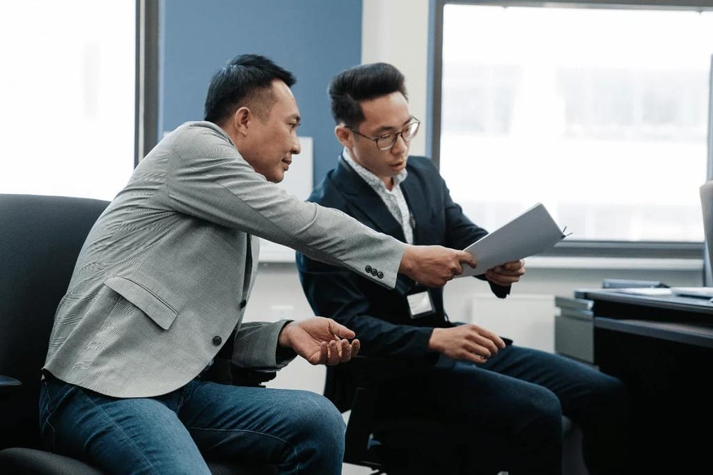 Colleagues discussing and analyzing paperwork during a meeting.