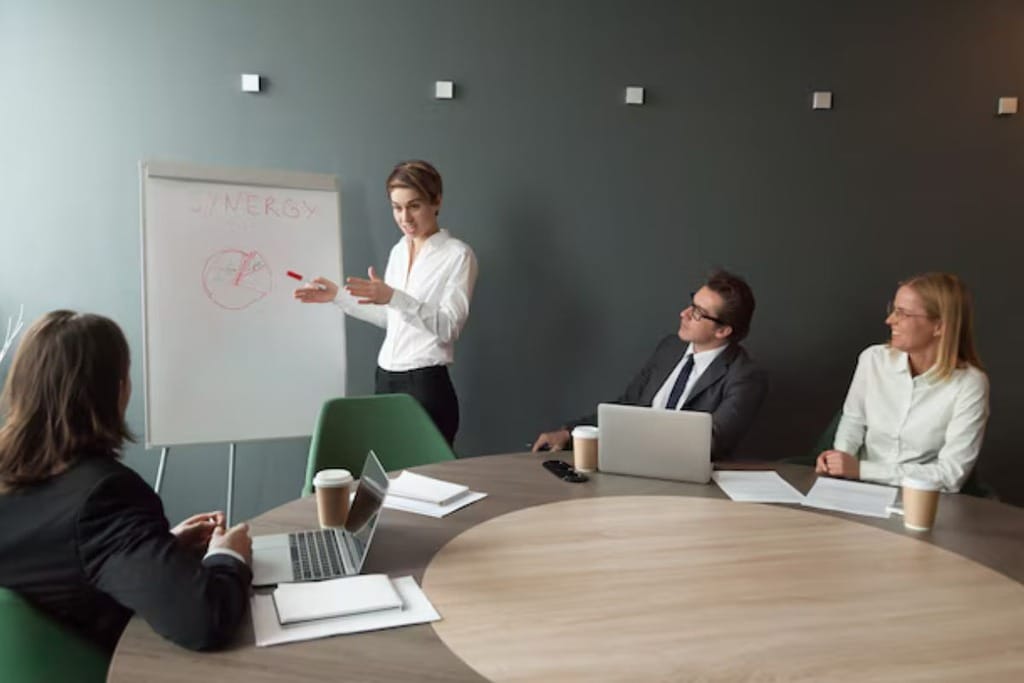 Group of diverse colleagues collaborating on a project in a modern office with a whiteboard.