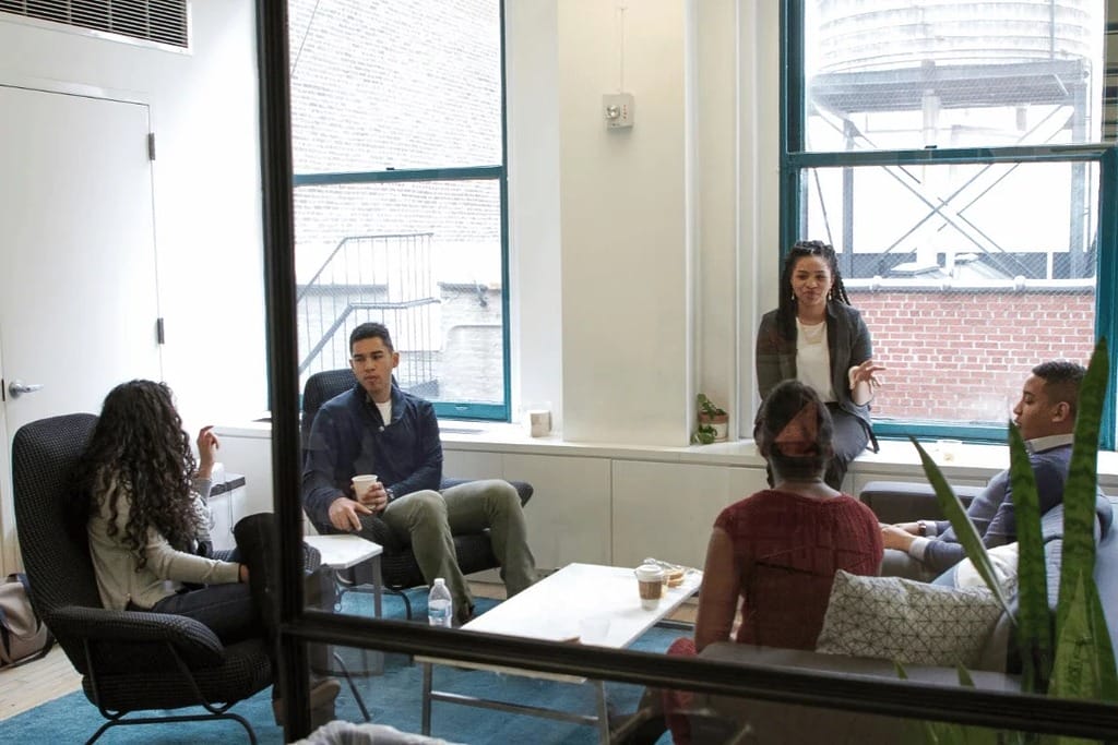 Female leader sharing ideas in a meeting with attentive colleagues.