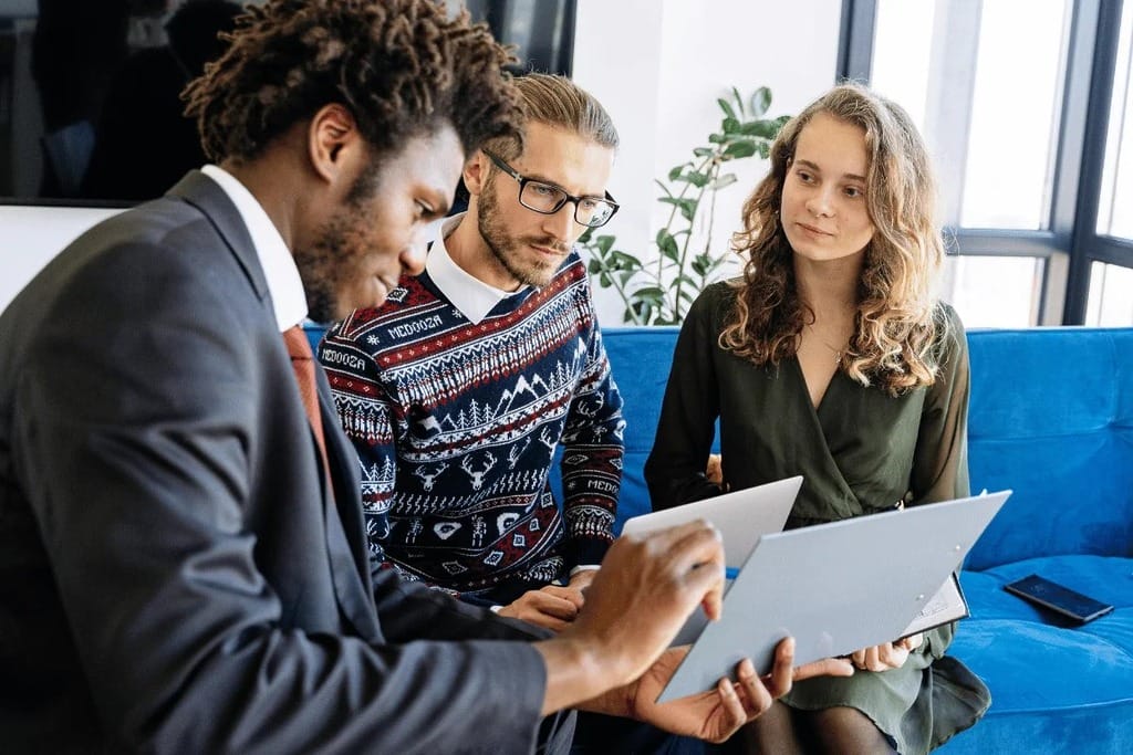 A team leader explaining a concept to colleagues during a meeting, with participants listening attentively.