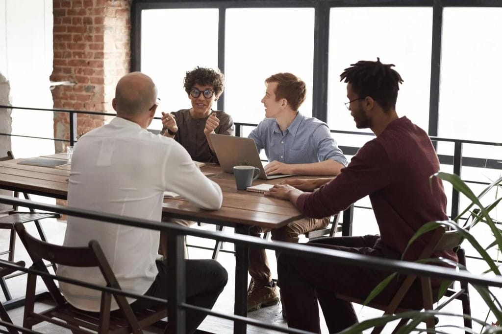Professional discussion with laptops and notebooks in a meeting.