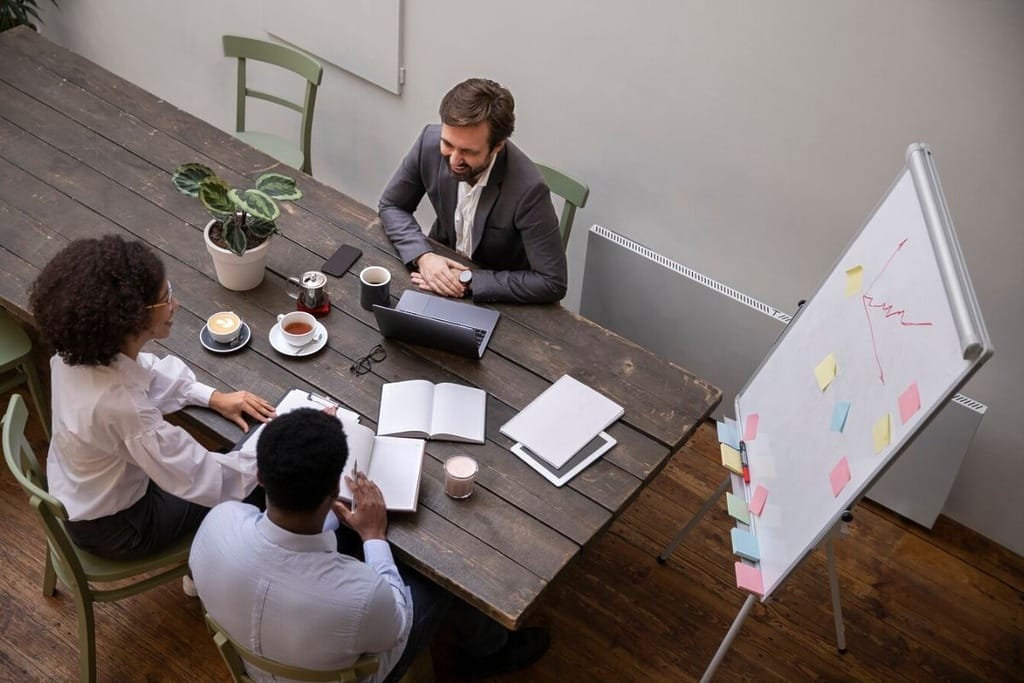 Office team collaborating on a project at a rustic wooden table.