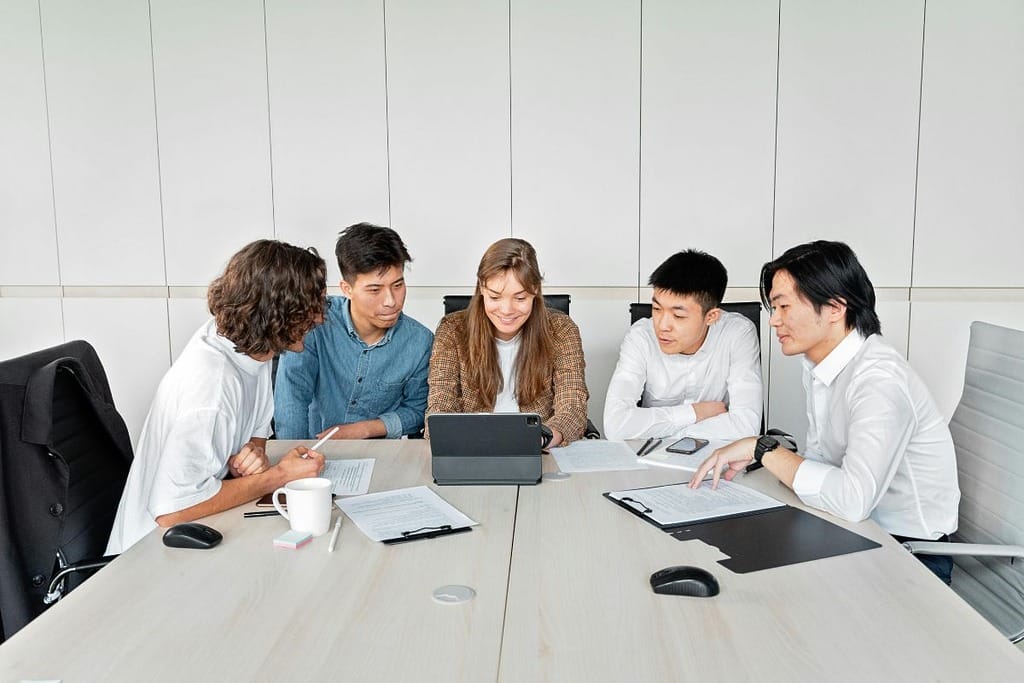 Team discussing a project while working on a laptop in a modern office.