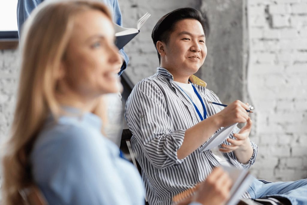 Smiling man taking notes during a workshop session.
